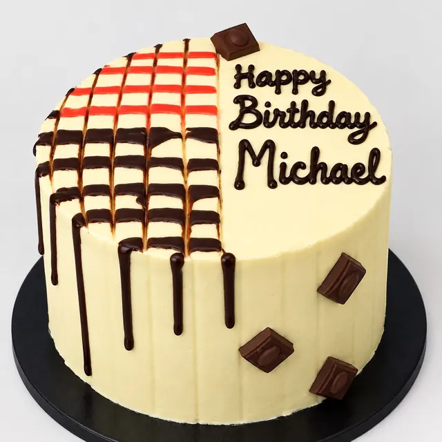 Birthday cake with chocolate drips and a hand-piped name in black icing