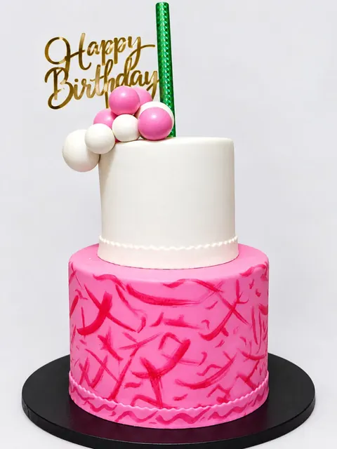 Two-tier white and pink birthday cake with a swirled pink base