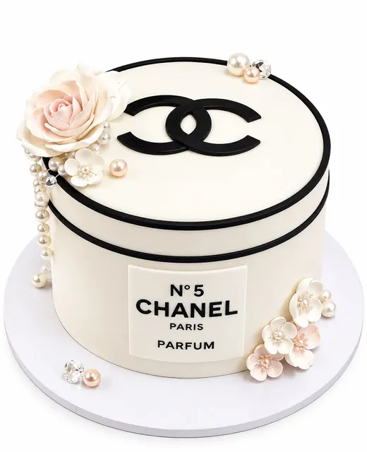 Round cake styled as a perfume box with a white sugar flower